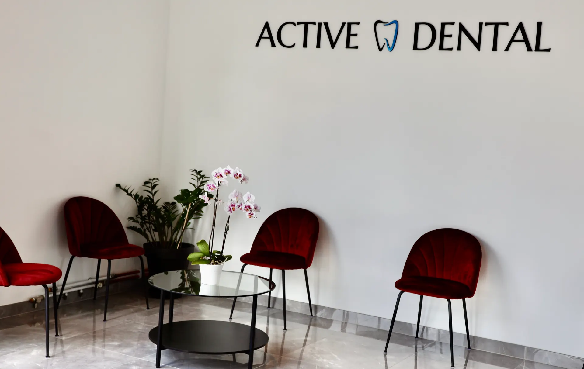 Väntrummet hos Active Dental med röda sammetsstolar